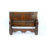 A 17thC oak double headboard, with a triple panelled back below carved tracery, together with a