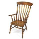 A Victorian oak and elm lath back kitchen chair, with solid saddle seat, raised on turned legs,