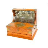 An Edwardian oak and brass bound three bottle tantalus and cigar box, the mirrored back tantalus