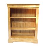 An oak open bookcase, fitted with two adjustable shelves, having a panelled and moulded top and on