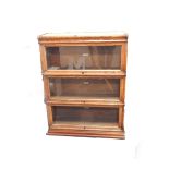 A Globe Wernicke oak bookcase, of triple section form, with glazed up and over doors, bears label,