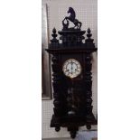 A Continental late 19th oak cased wall clock, circular brass dial with enamel chapter ring,