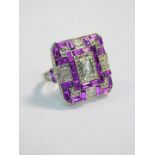 A modern Art Deco style dress ring, set with clear and lilac coloured paste, on a silver coloured