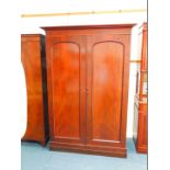 A Victorian mahogany double wardrobe, the outswept pediment over two doors, one enclosing a