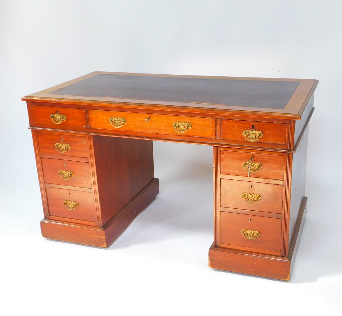 A Victorian mahogany twin pedestal desk, the rectangular top inset with tooled purple leather,