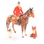 A Beswick model of a huntsman on a bay horse, 20cm H, together with a fox hound and seated fox. (3)