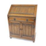An Old Charm oak bureau, with linen fold panel to the fall front, with shallow drawer below, and