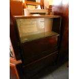A mid 20thC oak display cabinet, of trapezium form, with a pair of glazed doors, opening to reveal a