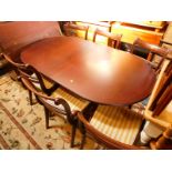 A Regency style mahogany twin pedestal dining table, with one addition leaf, raised on baluster