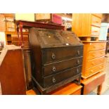 A 17thC style oak bureau, the fall flap opening to reveal drawers and recesses, over three long