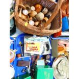 A group of treen, including eggs and turned wooden bowls, in a wicker basket, together with