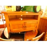 A light oak corner television cabinet, the hexagonal shaped top over a recess above cupboard