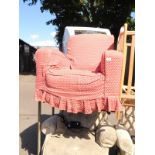 A mid 20thC armchair, upholstered in red foliate fabric, with loose over cover.