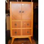 A 1950's teak linen press, with two doors opening to reveal a single shelf, above two drawers,