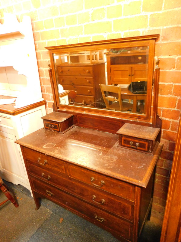 An Edwardian mahogany dressing chest, the swing frame mirror over two small drawers, above two short