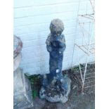 A reconstituted stone figure of a boy, atop a column flanked by a rabbit and a squirrel.