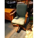 An office swivel chair, upholstered in green damask.