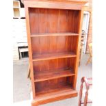 An oak open bookcase, the outswept pediment over three shelves, raised on a plinth base, 180cm high,