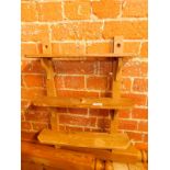 A rustic wall mounted set of three shelves, raised on straight uprights, 61cm H, 46cm W.