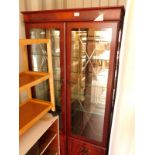 A flame mahogany display cabinet, the pediment over two engraved glazed doors, opening to reveal