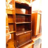 A mahogany waterfall bookcase, of three shelves, above a cupboard door, raised on bracket feet, 46cm