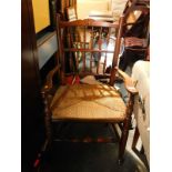 A set of three oak spindle back and rush seated dining chairs, comprising a carver and a pair of