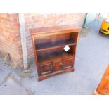 An oak open bookcase, with two shelves over a pair of doors, raised on bracket feet, 103cm H, 84cm