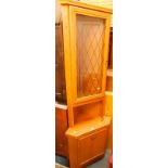 An MDF wood effect corner cupboard, the upper section with a glazed door, above a cupboard door on a