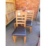 A set of three Zone Relaxateeze light oak and brown leather upholstered single dining chairs.