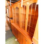 A pair of yew wood laminate display cabinets, the moulded pediment over a pair of glazed doors, each