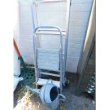 A folding stepladder, an extending ladder and a watering can. (3)