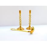 A pair of spiral fluted brass candlesticks, 30cm H., together with a brass soup ladle, 38cm H. (3)