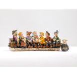 A Will Young Widecombe pottery figure group of Uncle Tom Cobley and All., seated on a bench, painted