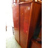 An Austin Suite 1950's teak gentleman's wardrobe, with two doors opening to reveal a hanging rail,