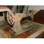 A Singer oak and cast iron sewing machine table, with a Singer Egyptianesque sewing machine, 75cm H,