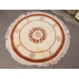 A modern Chinese style circular rug, of cream and brown design, 120cm diameter.