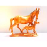 A wooden sculpture of a horse and foal, 33cm wide, 32cm high.