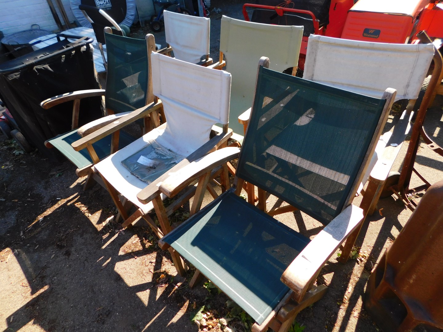 Four teak director's chairs, three with covers, together with two folding chairs. (6)