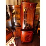 Two mahogany corner cabinets, each with a dentil moulded cornice, over a glazed door enclosing two