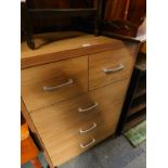 A light chipboard chest, of two short over three long drawers, 116.5cm H, 78cm W, 44.5cm D.