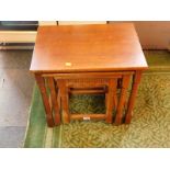 A Continental oak nest of occasional tables, raised on turned supports, united by a box framed