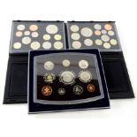A Royal Mint Millennium United Kingdom uncirculated coin set and two others, for 2010 and 2011, in