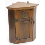 A 20thC oak hanging corner cabinet, of small proportion with elaborate lock, 55cm high, 47cm wide,