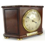 An early 20thC mahogany cased mantel clock, in shaped case, with upper beading on compressed orb