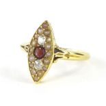 An 18ct gold dress ring, the lozenge shaped head centred by a red stone, flanked by two small