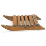 An early 20thC pine sleigh, with slated top on a shaped base, 14cm high, 80cm wide, 40cm deep.