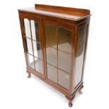 A mid 20thC mahogany display cabinet, with two glazed doors, on compressed cabriole legs, 121cm
