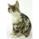 A 20thC Winstanley pottery figure of a cat, in standing pose with glass eyes, looking forlorn,