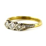 An 18ct gold and platinum diamond dress ring, set with three illusion set diamonds, in an Art Deco