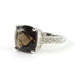 A 9ct gold dress ring, claw set with a smoky quartz style stone, flanked by small white stones to